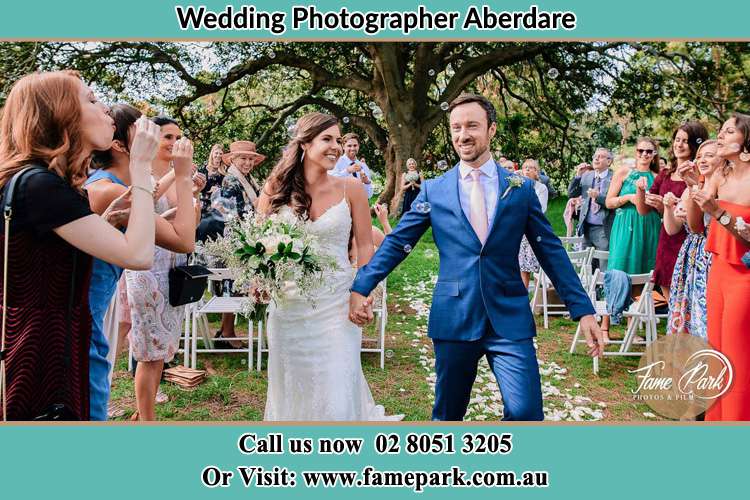 Photo of bride and groom walking hold hands Aberdare