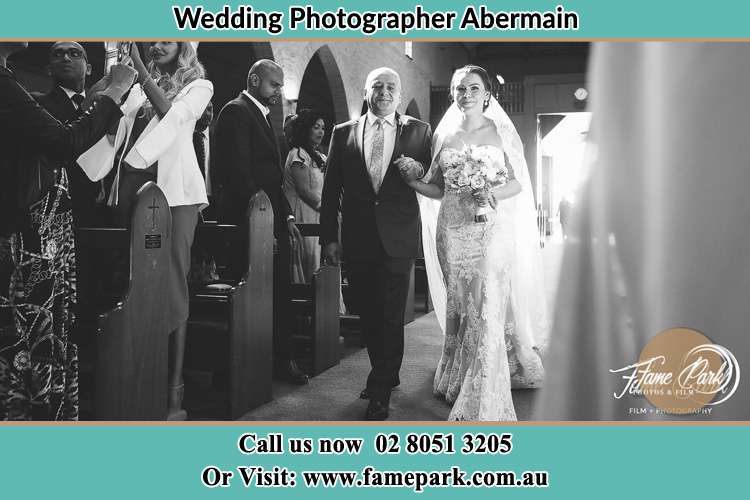 Photo of the Bride with her father walking in the aisle Abermain