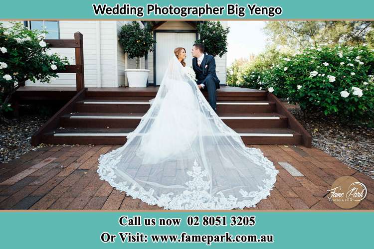 Photo of the Bride and Groom siitting in the stairs Big Yengo