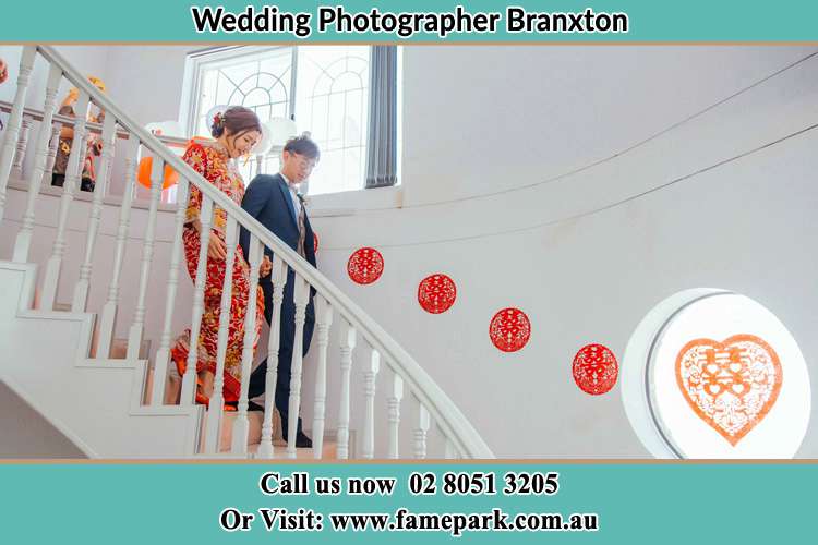 Photo of the Bride and the Groom walking down the stairs Branxton