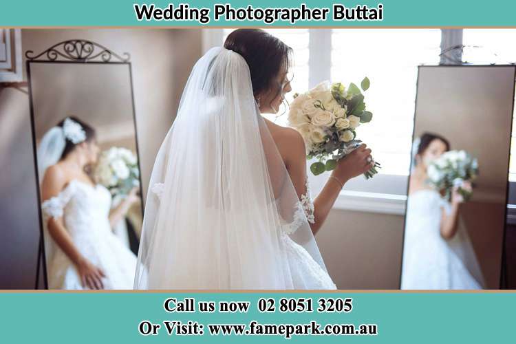 Photo of the Bride holding flower in front of the mirrors Buttai NSW 2323