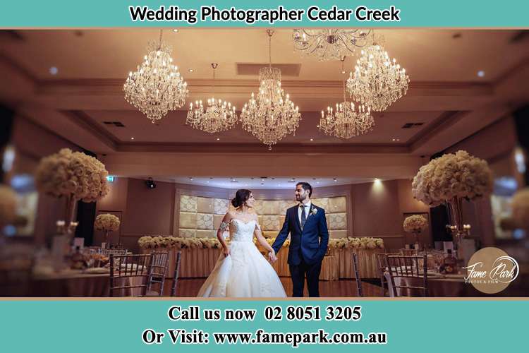 Photo of the Bride and the Groom holding and looking each other on the dance floor Cedar Creek NSW 2325