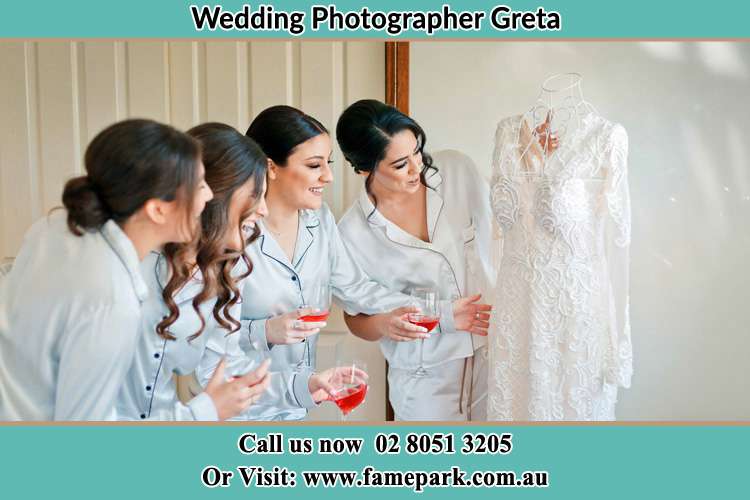 Photo of the Bride and the Bride's Maid looking at the gown Greta