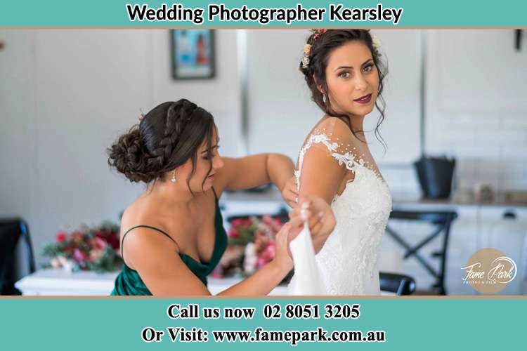 Photo of the Bride helping by her bridesmaids fitting her wedding gown Kearsley NSW 2325