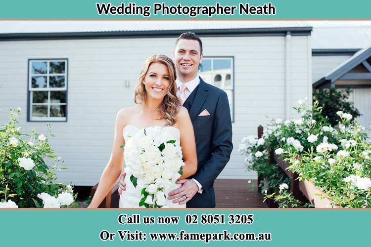 The Bride and the Groom smiling at the camera outside the house Neath NSW 2326