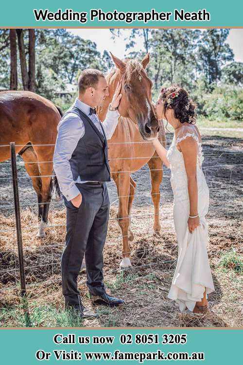 Photo of the Groom holding the horse while the Bride give a kiss Neath NSW 2326