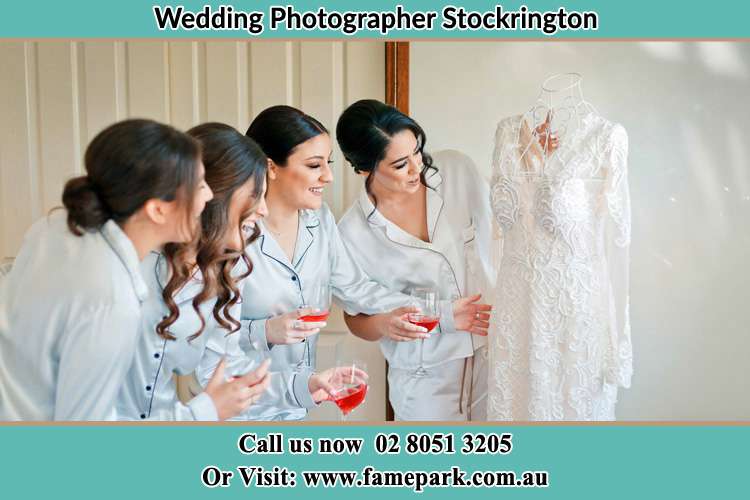 Photo of the Bride and her bridesmaids looking to her wedding gown Stockrington NSW 2322